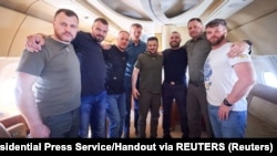 Ukrayina prezidenti Volodımır Zelenskıy (ortada), Prezident ofisiniñ reberi, İİN yolbaşçısı ve "Azov" polkunıñ beş komandiri