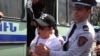 Armenia - A police officer uses force against a protester blocking a street in Yerevan, April 25, 2024.