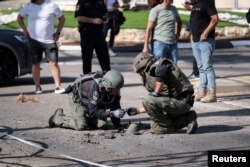 Израил аскерлери Ливандан атылган ракетанын калдыктарын текшерүүдө.