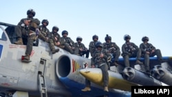 Пілоти Повітряних сил ЗСУ позують для фото, сидячи на штурмовику Су-25, на своїй базі на сході України, 4 травня 2023 року 
