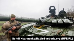 Український військовий біля пошкодженого російського танка Т-72БЗ під час масштабного вторгнення Росії до України. Донецька область, 13 квітня 2022 року
