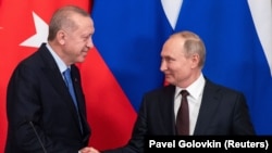 RUSSIA -- Russian President Vladimir Putin and Turkish President Tayyip Erdogan shake hands during a news conference following their talks in Moscow, March 5, 2020