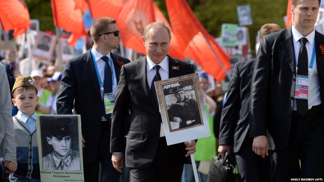 Ruski predsjednik Vladimir Putin (u sredini) nosi portret svog oca na maršu Besmrtnog puka tokom proslave Dana pobjede u Moskvi 9. maja 2015.