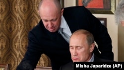 "Путиндин ашпозчусу" делген ишкер Евгений Пригожин (солдо) президент Владимир Путин менен. Сүрөт 2011-жылы тартылган. 