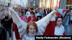 Белорусија - жена го носи белоруското знаме за време на опозициските протести во Минск против резултатите на претседателските избори во земјата. 28.08.2020.