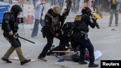 Law enforcement officers detain a protester following multiple detentions by ICE in downtown Los Angeles, California, on June 6. 