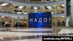 Надпіс «Надо» на мультымэдыйным экране ў гандлёвым цэнтры «Сталіца» ў Менску, лістапад 2024