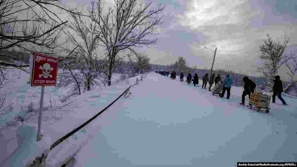 Далі нам не можна. Там «крайня» позиція ЗСУ, а за нею вже бойовики. Мовчазна колона людей зникає за поворотом дороги. Там підірваний міст...
