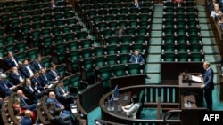 Prim-ministrul polonez Donald Tusk vorbește în Parlament. Locurile parlamentarilor de opoziție ale partidului Lege și Justiție (PiS) sunt goale în fundal înainte de votul de încredere pentru cabinetul său de la Varșovia, pe 11 iunie 2025.