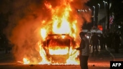 Un vehicul a fost incendiat de protestatari în timpul protestelor anti-imigranți din Ballymena, Irlanda de Nord. 10 iunie 2025.