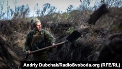 Український військовий копає окоп на запасних позиціях у зоні потенційного розведення військ поблизу Богданівки на Донеччині 