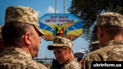 Військовослужбовці біля знаку «Вас вітає місто Торецьк» під час заходів із нагоди четвертої річниці визволення Торецька від російських гібридних сил. Торецьк, 21 липня 2018 року