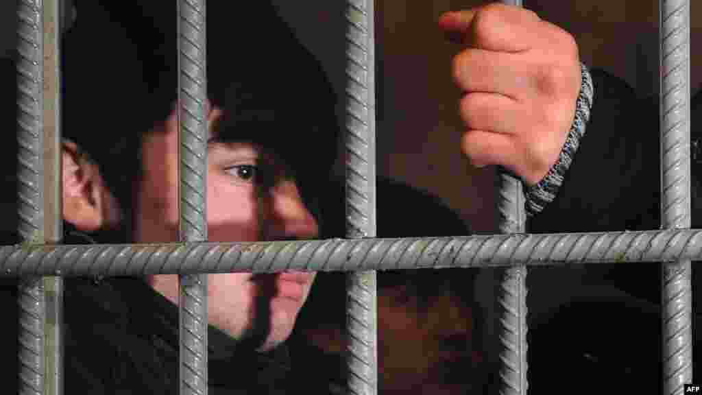 Задержанный нелегальный иммигрант из Узбекистана в КПЗ на Казанском вокзале Москвы 24 января. Полиция в этот день задержала на вокзале около 30 нелегалов. В статье, опубликованной накануне в рамках предвыборной кампании, в то время премьер-министр Владимир Путин обещал ужесточить иммиграционное законодательство. (AFP/Андрей Смирнов)