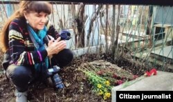 Fotograf Umida Ahmedova rassom qabri ustida qur’on tilovat qilmoqda